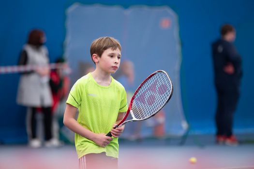 Little boy with a tennis racket. The child plays tennis.