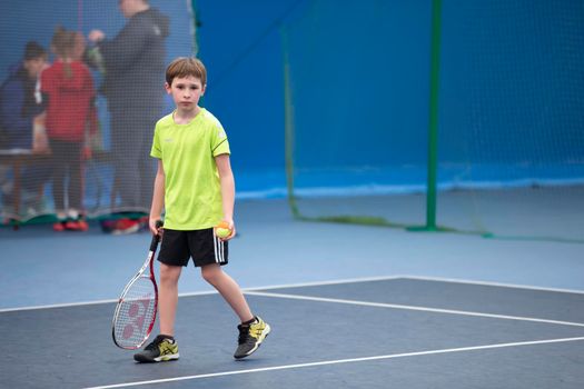 Little boy with a tennis racket. The child plays tennis.