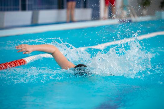 An athlete is swimming in the sports pool.