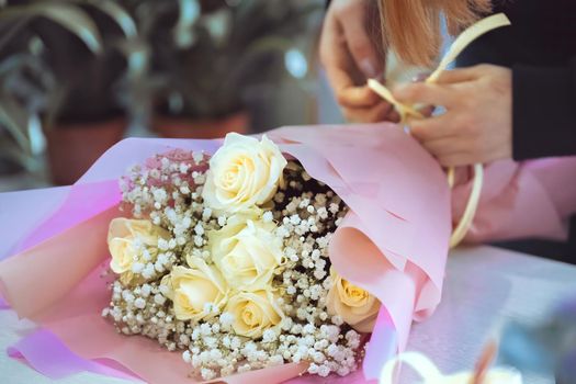 Florist at work, woman making fashion bouquet of rose flowers. download photo