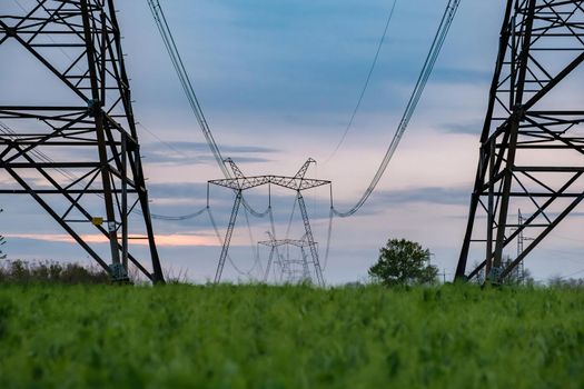 Power line posts. high voltage tower with the sky. Electricity pylon with beautiful calm sky on the background. Electrical pylons. Download photo