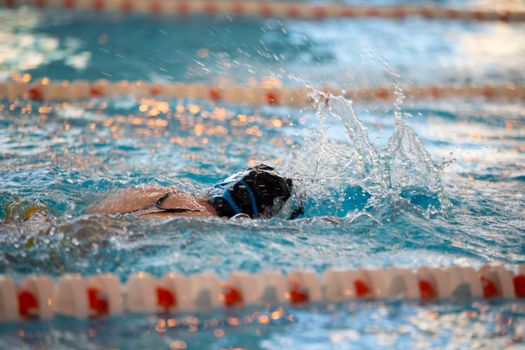 Child athlete swims in the pool. Swimming section.