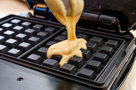 Modern waffle maker with ingredients, homemade Belgian waffles.