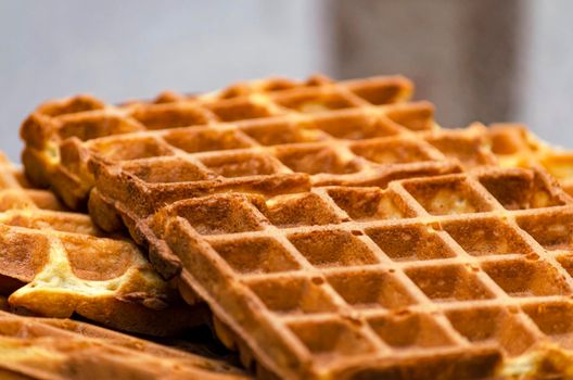 homemade belgian waffles, crispy waffles close-up on the table.