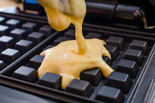 The process of making waffles. Belgian waffles cooking process.