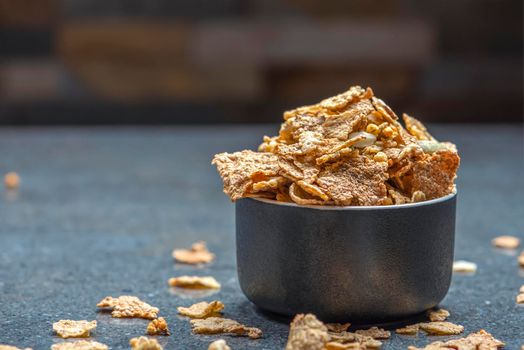 Dry muesli in a saucer on the background of a stone table top. Healthy food and light diet breakfast concept, copy space.