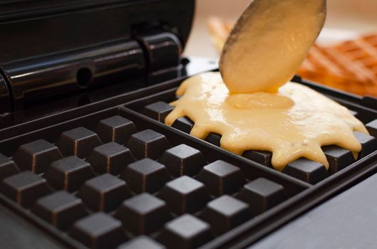 Modern waffle maker with ingredients, homemade Belgian waffles.