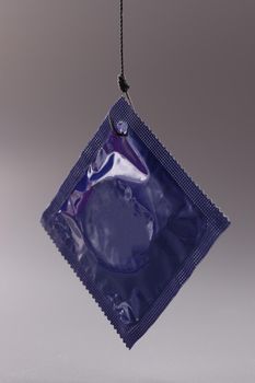 Blue condom packaging on gray background. Safe sex rules concept