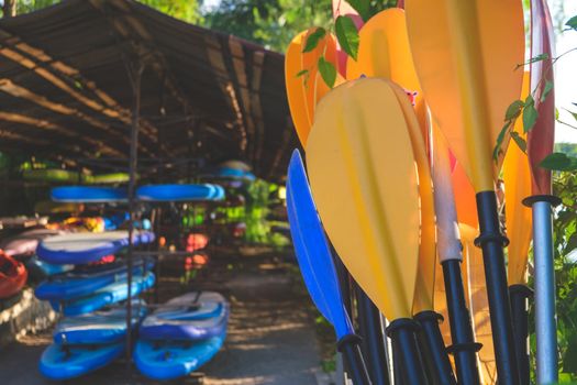 blades of paddles various colors with kayaks background , paddling concept