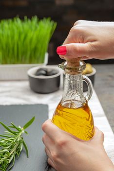 Olive oil. A woman pours olive oil into a saucer