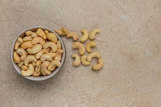 Shelled cashews and hazelnuts. Banner with nuts. Nuts in a saucer on a stone table top, top view. Place to insert text or design.