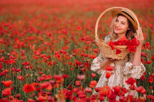 a girl in a dress with a hat and with a basket in a field with poppies.