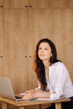 Beautiful woman sitting in the office working on a laptop.