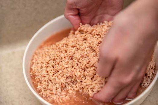 Cooking pilaf in a cauldron, a recipe for real pilaf. Soak rice in a container of water before cooking. Devzira rice for pilaf. Cooking pilaf at home.
