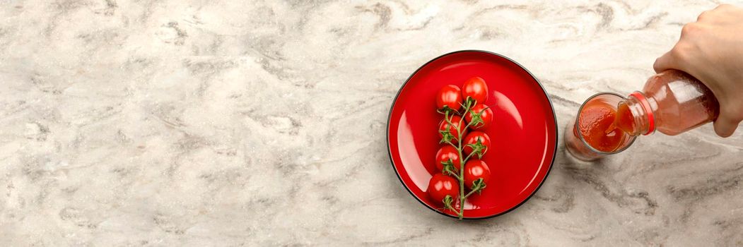 Pour tomato juice into a glass. Hand pours tomato juice from bottle into glass, marble table top background