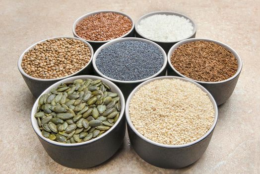 Various seeds on a marble background. Assortment, seeds set, healthy food ingredients, superfoods, copy space. Sunflower, flax, pumpkin, cannabis poppy seeds