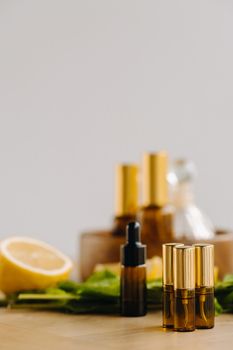 Essential oil in bottles with lemon and mint fragrance lying on a wooden surface.