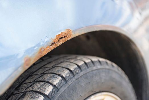 .Corrosion of metal on a car body, close-up. Rust on the car door. Selective focus.