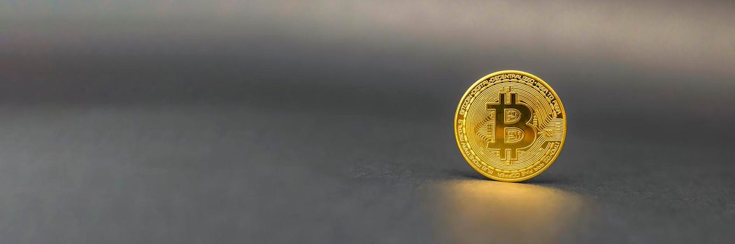 Bitcoin symbol in gold color on a black background. The concept of crypto currencies as the future of the economy