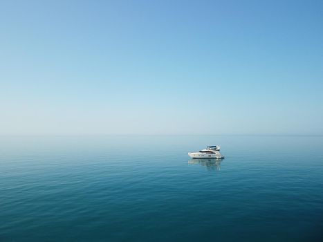 Aerial boat race. Luxury cruise trip. View from above of white boat on deep blue water. Aerial view of rich yacht sailing sea. Motor boat racing wave. Summer journey on luxury ship