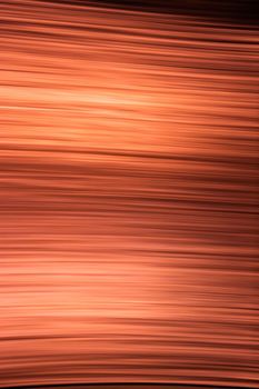 Abstract orange black background made of thin wavy lines and highlights. Vertical back