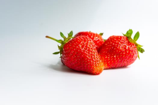 Red ripe juicy strawberries on a white gray background. Sweet natural dessert.