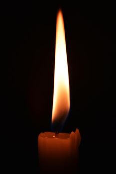 Close up photo of a burning candle on a black background