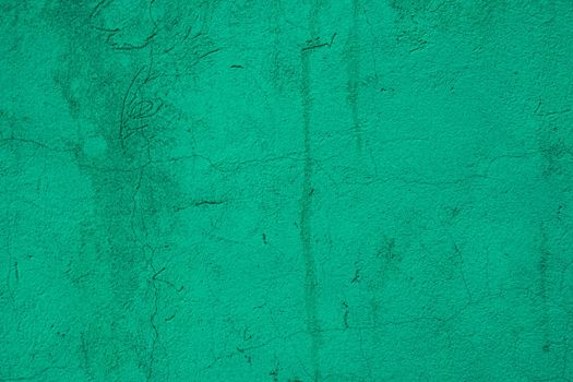 Scuffed peeling green plaster on the wall.