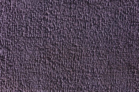 Relief surface of the wall close-up. Relief shabby purple wall.