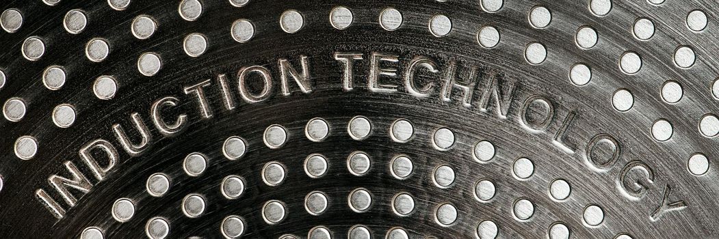 Bottom of induction cookware. Texture of a non-stick induction pan close-up.