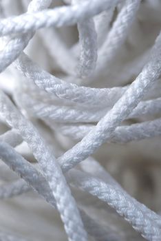 Thick tangled white rope close up. Close-up of an worn out boat rope as a nautical background