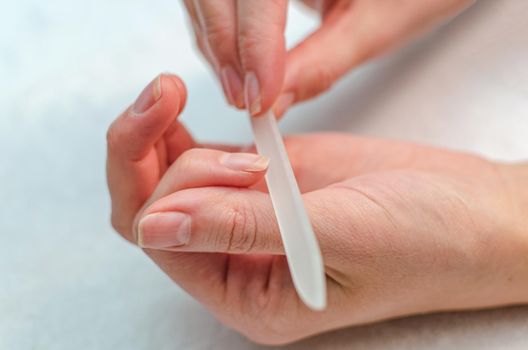 woman makes herself a manicure with a nail file at home.Hygiene and nail care.