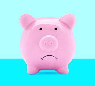 Close up of a sad pink piggy bank on white background