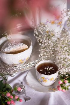 white still life with cheesecake gypsophila and cup of tea, light and airy, High quality photo,table setting for tea drinking in the English style