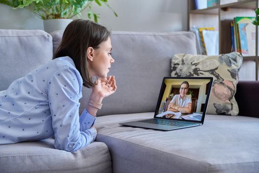 Online therapy meeting of young woman with psychologist. Female lying on couch at home talking with concellor, using laptop for conference call video chat. Technology, psychology, youth, mental health