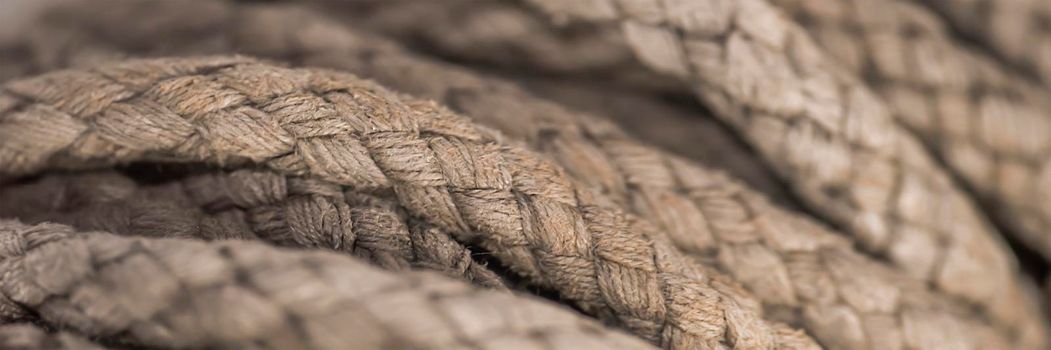 Thick tangled rope close up. Close-up of an old worn out boat rope as a nautical background
