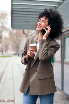 young latin businesswoman talking happy on the phone outdoors, concept of communication and urban lifestyle