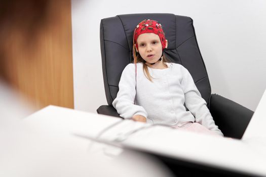 Focus on a young patient talking to the doctor during a biofeedback session