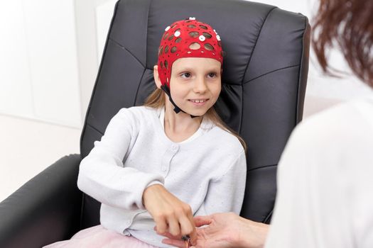 Caucasian girl and doctor at a clinic during biofeedback treatment