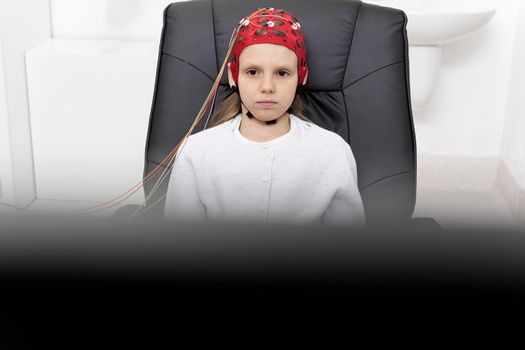 Focus on a young patient looking to a screen during a biofeedback session