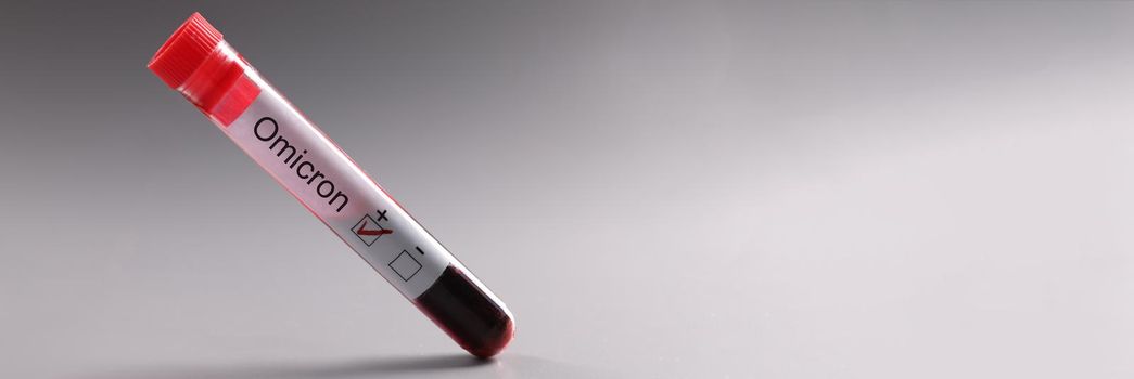 Test tube of blood with positive test result for coronavirus infection omicron closeup. New strains of coronavirus concept