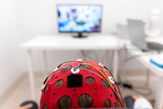 Focus on the headgear on a patient's while monitoring the impulses during a biofeedback session