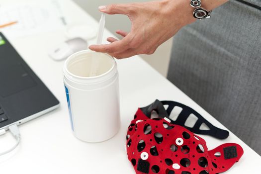 Hand of a doctor preparing material for a biofeedback session in a clinic