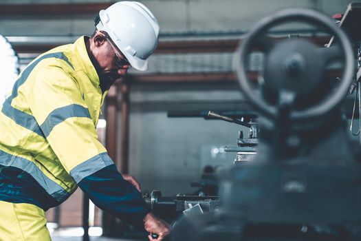 Factory worker or engineer do machine job in adept manufacturing workshop . Industrial people and manufacturing labor concept .