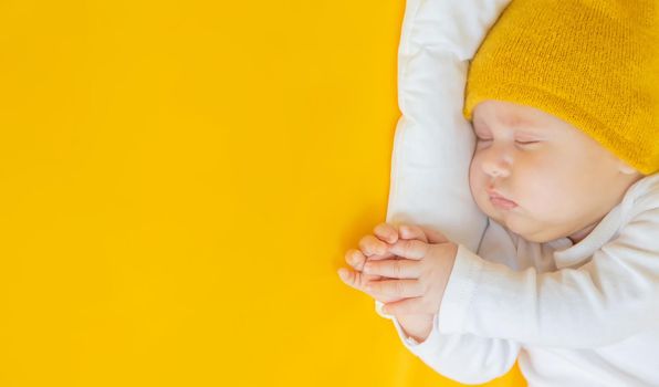 Baby sleeps on a yellow background. Selective focus. People. Merry Christmas and Happy New Year, Holidays greeting card background. Selective focus.