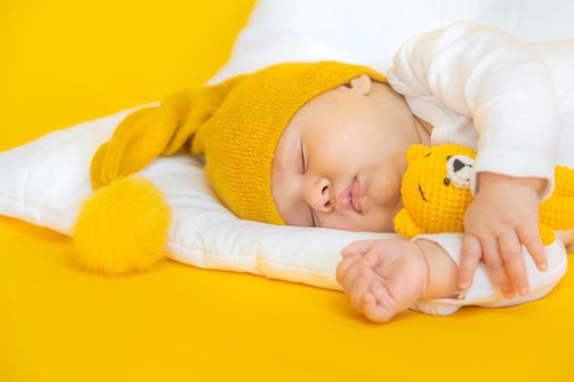 Baby sleeps on a yellow background. Selective focus. People. Merry Christmas and Happy New Year, Holidays greeting card background. Selective focus.