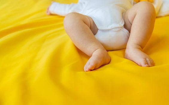 Baby feet on a yellow background. Selective focus. People. Merry Christmas and Happy New Year, Holidays greeting card background. Selective focus.