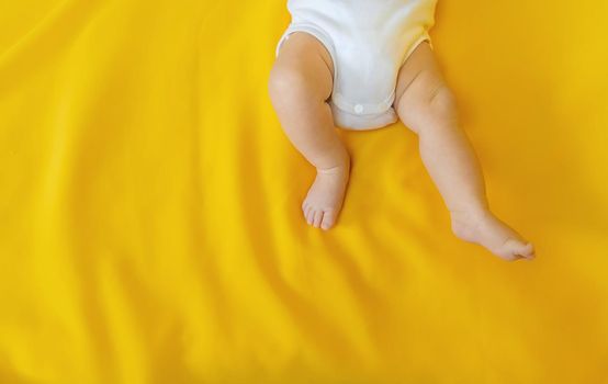 Baby feet on a yellow background. Selective focus. People. Merry Christmas and Happy New Year, Holidays greeting card background. Selective focus.