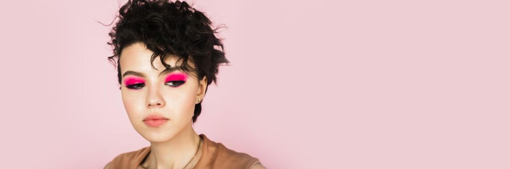 Portrait of a beautiful model with bright pink make-up and bright flying hair. Beautiful lips and makeup. Sexy girl with short hair. Web banner.