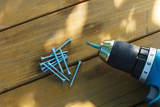 self-tapping screw and screwdriver on a wooden board